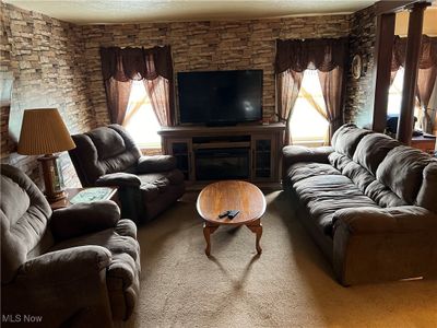 Living room featuring a textured ceiling, plenty of natural light, and carpet flooring | Image 3