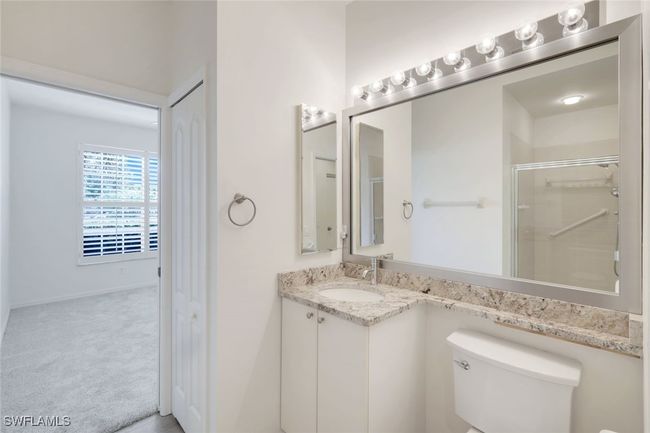 Bathroom featuring vanity, toilet, and a shower with door | Image 15