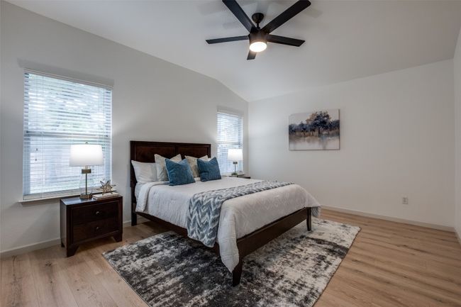 Bedroom with light wood-style floors, baseboards, a ceiling fan, and vaulted ceiling | Image 18