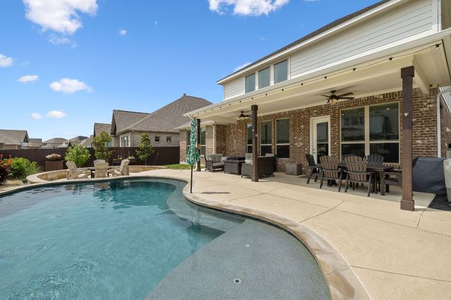 View of swimming pool featuring shallow area with umbrella stand | Image 8
