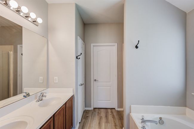 Bathroom with wood finished floors, a bath, and double vanity | Image 19