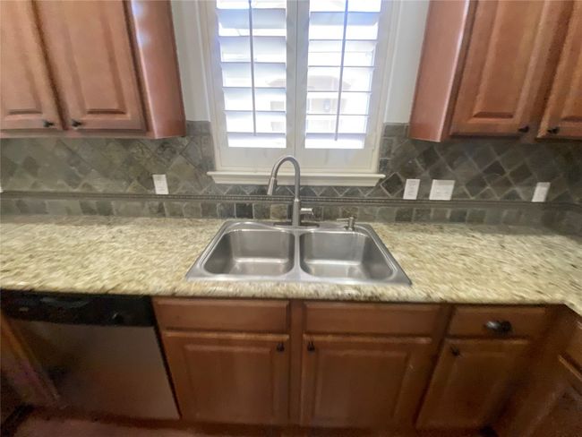 Kitchen features a deep stainless sink, dishwasher, granite countertops, and backsplash | Image 10