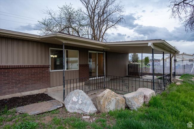 View of exterior entry featuring brick siding, board and batten siding, and fence | Image 29
