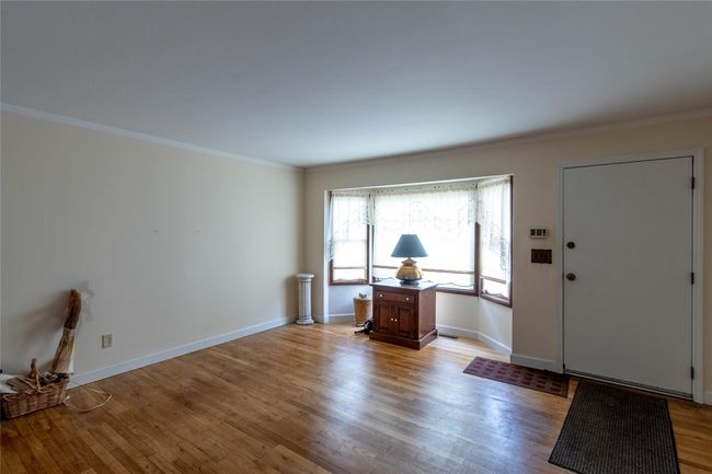 Entrance foyer featuring light wood finished floors, baseboards, and crown molding | Image 6