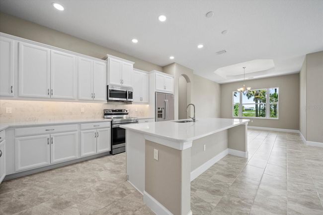 The home's kitchen features a large island with seating space | Image 15