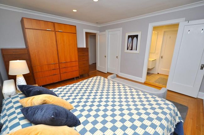 Corner main bedroom has hardwood floor and access to the renovated bathroom. The bedroom is 14'-7" x 13'-2". | Image 21