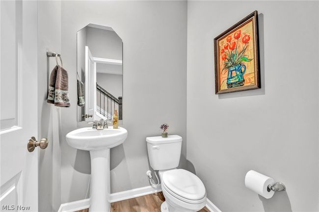 Bathroom featuring sink, toilet, and wood-type flooring | Image 26