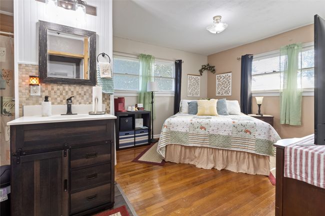 Bedroom with wood finished floors and a sink | Image 17