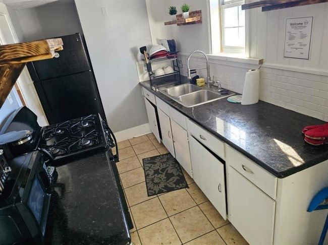 Modern kitchen with ample counter space and natural light in a cozy two-bedroom unit. | Image 15