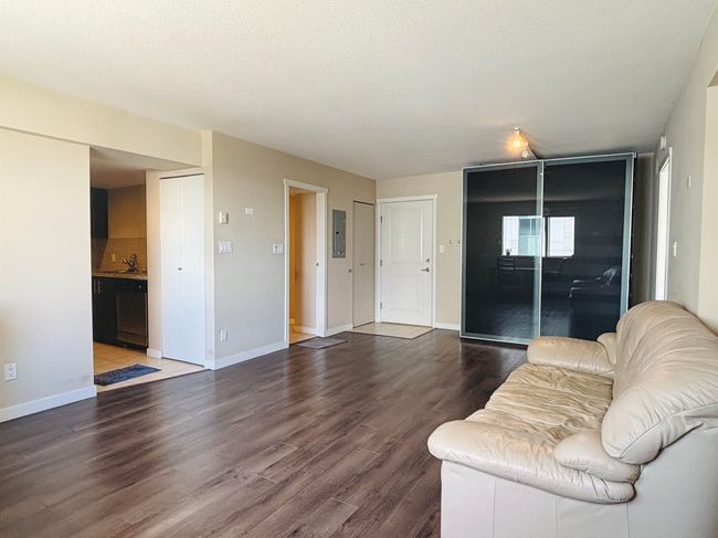 Living room featuring baseboards, dark wood-type flooring, and electric panel | Image 9