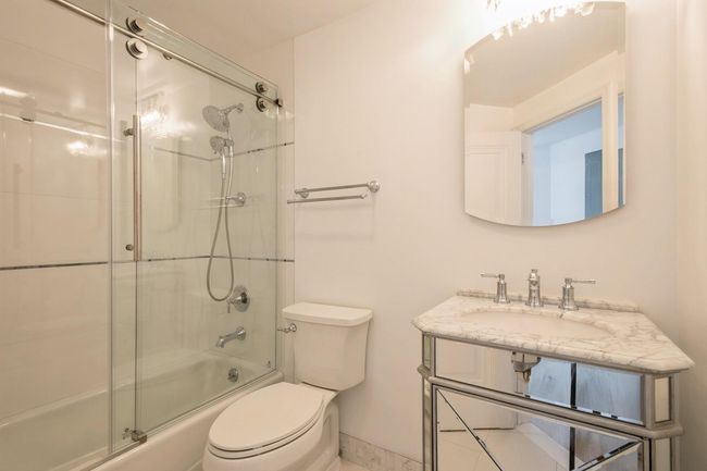Bathroom with enclosed tub / shower combo and vanity | Image 16