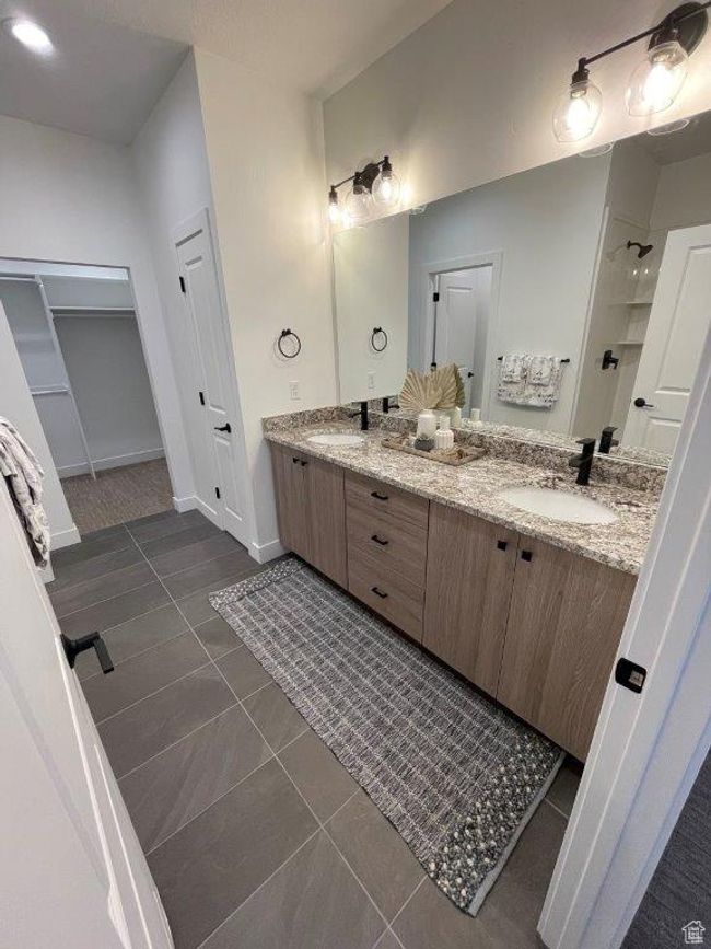 Bathroom with tile patterned floors, double vanity, a closet, and a shower | Image 7