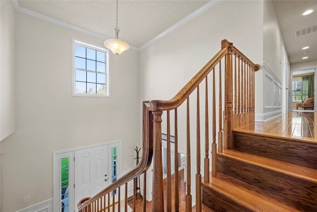 Gleaming hardwood stair treads lead to the second level where the hardwoods continue. | Image 24