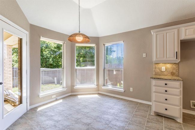 Unfurnished dining area with vaulted ceiling, baseboards, and light tile patterned floors | Image 13