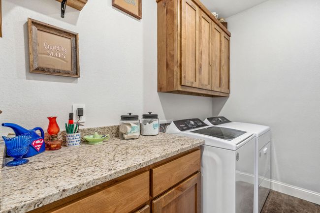 Washroom featuring separate washer and dryer, cabinet space, and baseboards | Image 16