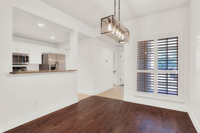 Unfurnished dining area with light wood-style flooring, recessed lighting, and a chandelier | Image 5