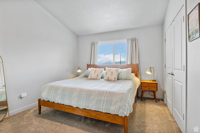 Bedroom with baseboards, carpet flooring, a textured ceiling, and a closet | Image 23
