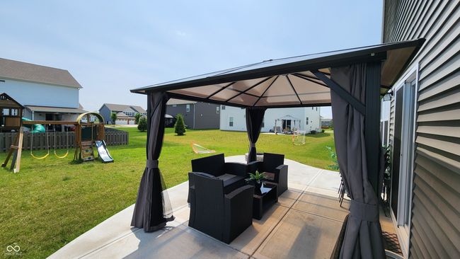 view of patio / terrace with a gazebo, a playground, a residential view, and an outdoor hangout area | Image 21