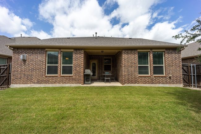 Rear view of property with brick siding, a patio area, and a wall unit AC | Image 22