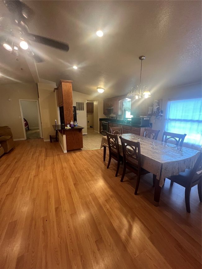 Dining room with lofted ceiling, light wood-style floors, a chandelier, and a textured ceiling | Image 9