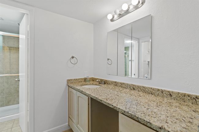 Downstairs utility room with granite counter tops, decorative lighting and sink. | Image 15
