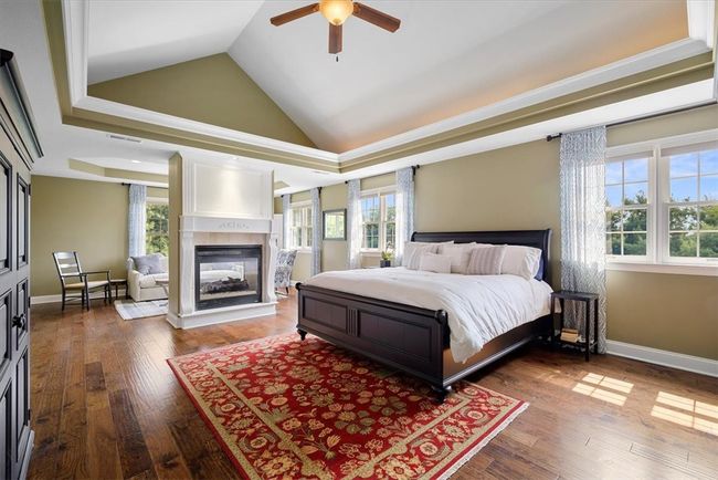 Retreat to the tranquil master suite residing on the upper level enhanced by a double tray ceiling and a double-sided fireplace into the sitting room. | Image 22
