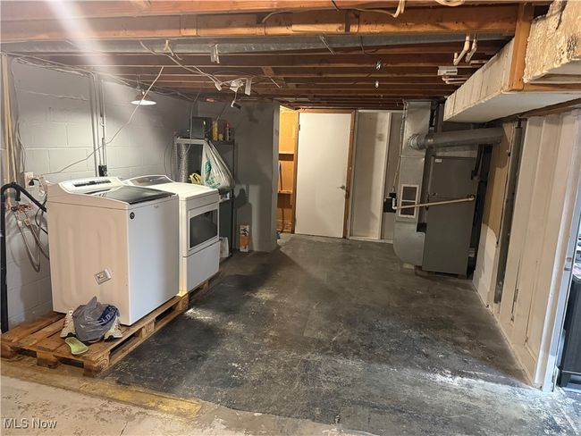 Unfinished below grade area with washing machine and clothes dryer and heating unit | Image 14