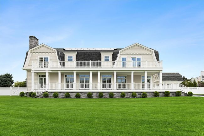 Shingle-style home featuring a gambrel roof, a balcony, solar panels, a porch, and a chimney | Image 46