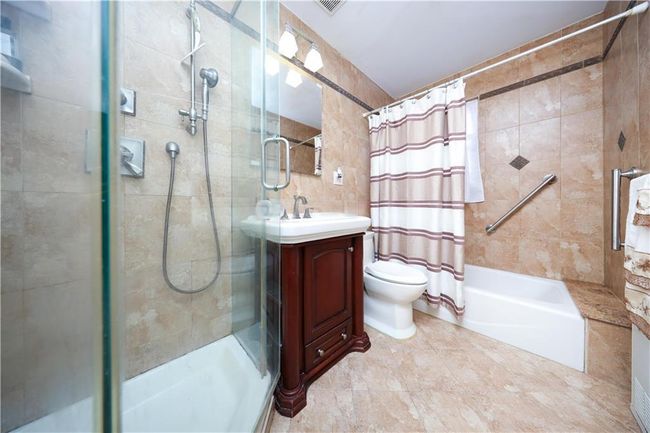 Full bathroom featuring vanity, tile walls, and shower / tub combo with curtain | Image 24