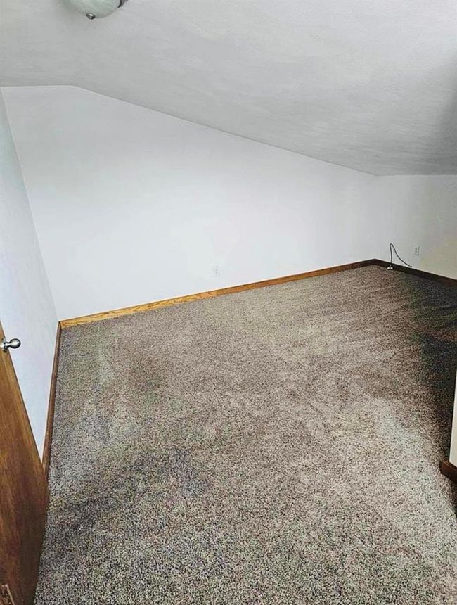 Additional living space with carpet floors, baseboards, and lofted ceiling | Image 20