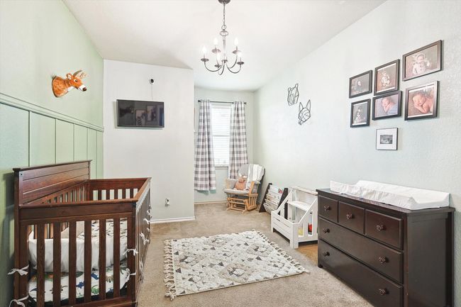 Carpeted bedroom featuring a chandelier and a crib | Image 19