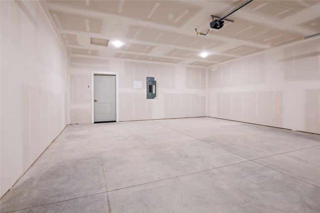 Garage featuring electric panel and a garage door opener | Image 26