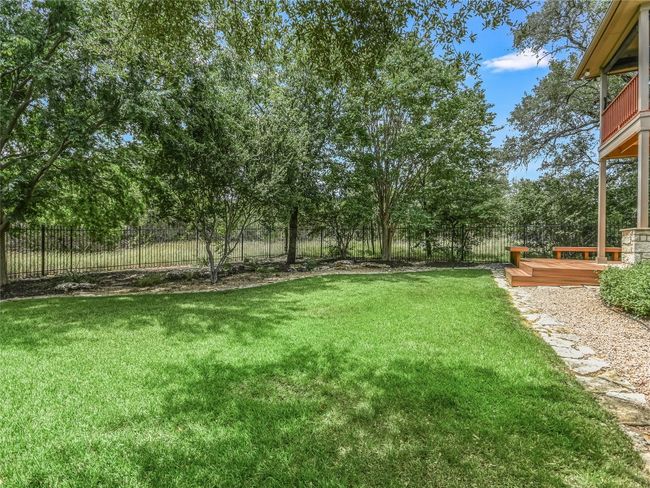 View of side green space from backyard zoysia lawn. | Image 28