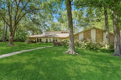 Generous front yard brick with brick walkway, mature trees and attractive landscape lighting. | Image 2