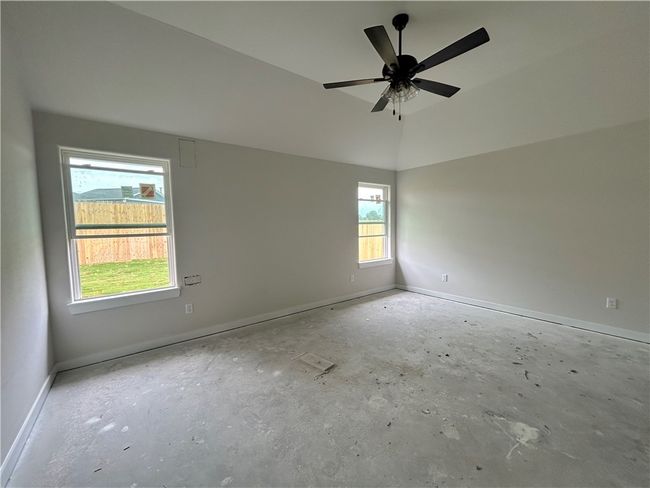Empty room with a ceiling fan and concrete flooring | Image 9