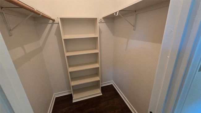 Spacious closet with dark wood-style flooring | Image 17