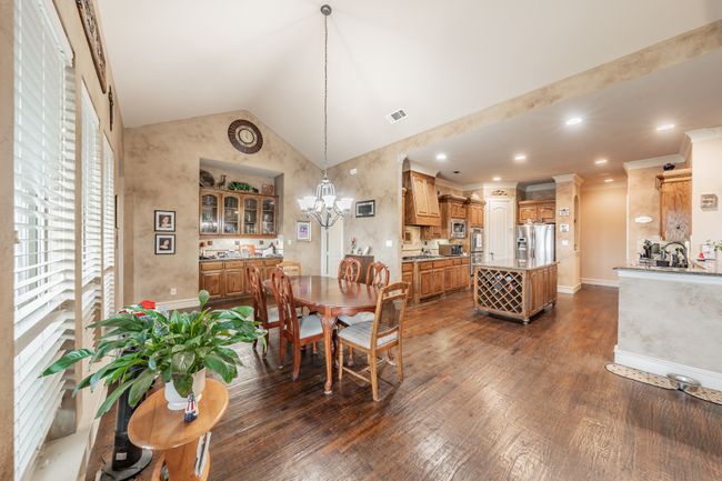 Dining room featuring dark wood-style flooring, lofted ceiling, and a chandelier | Image 16