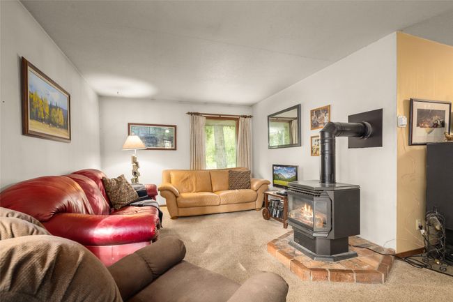 Living area with a wood stove and carpet floors | Image 18