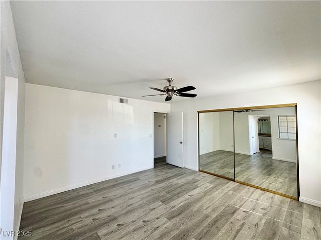 Primary bedroom with wood finished floors, a closet, and a ceiling fan | Image 14