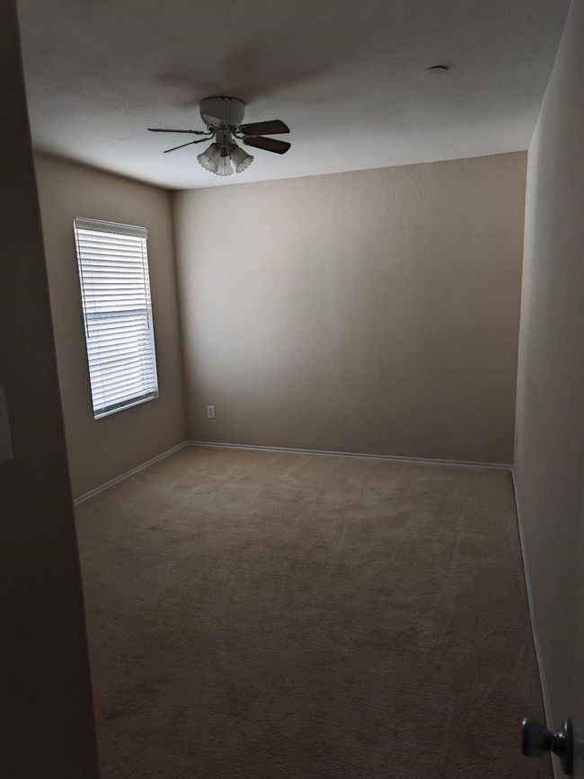 Spare room featuring ceiling fan, carpet floors, and baseboards | Image 12