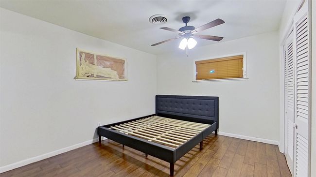 Bedroom with wood finished floors, baseboards, a closet, and a ceiling fan | Image 12