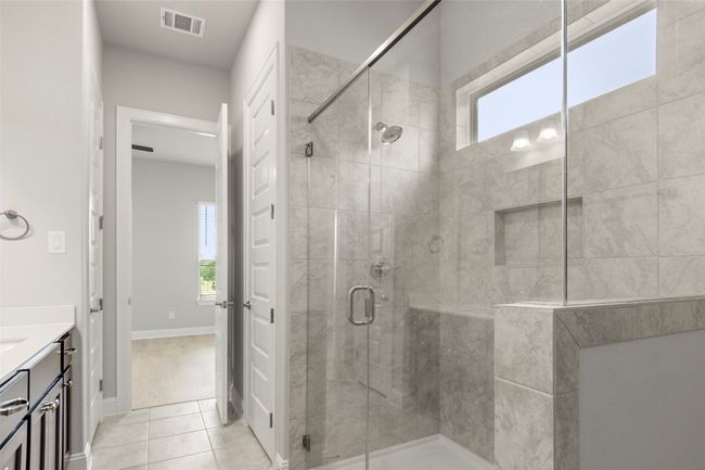 Bathroom with plenty of natural light, a shower stall, vanity, and tile patterned floors | Image 28