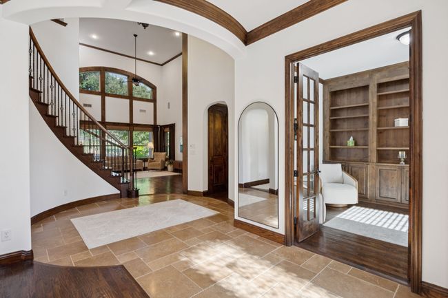 Foyer with arched walkways, crown molding, stairs, french doors, and ceiling fan | Image 4