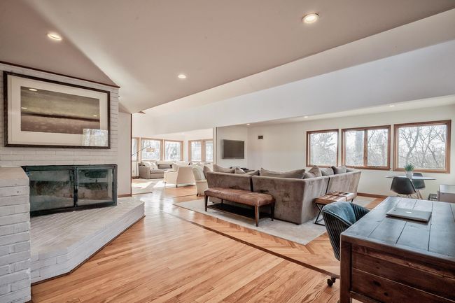 Living room featuring a brick fireplace, lofted ceiling, and recessed lighting | Image 4