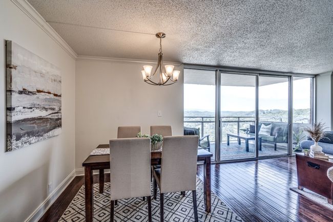 Floor to ceiling windows frame the majestic mountains in the distance, creating a mesmerizing backdrop for your meals whether you're hosting a formal dinner party or enjoying a casual family dinner. The dining table, four chairs, and rug stay. | Image 6