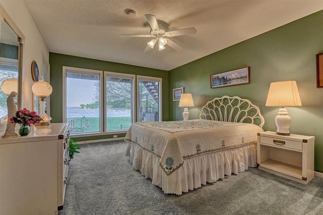 A first floor guest bedroom offers picture windows that frame beautiful views of the lake. | Image 30