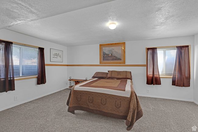 Carpeted bedroom featuring a textured ceiling and baseboards | Image 28