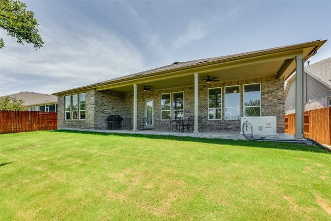 Rear view of property featuring brick siding, ceiling fan, and a patio | Image 26