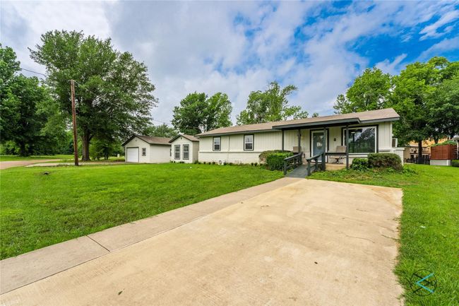 Ranch-style house with a front yard, a garage, and covered porch | Image 13