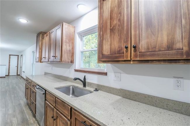 Kitchen with light stone counters, sink, light hardwood / wood-style floors, and dishwasher | Image 10